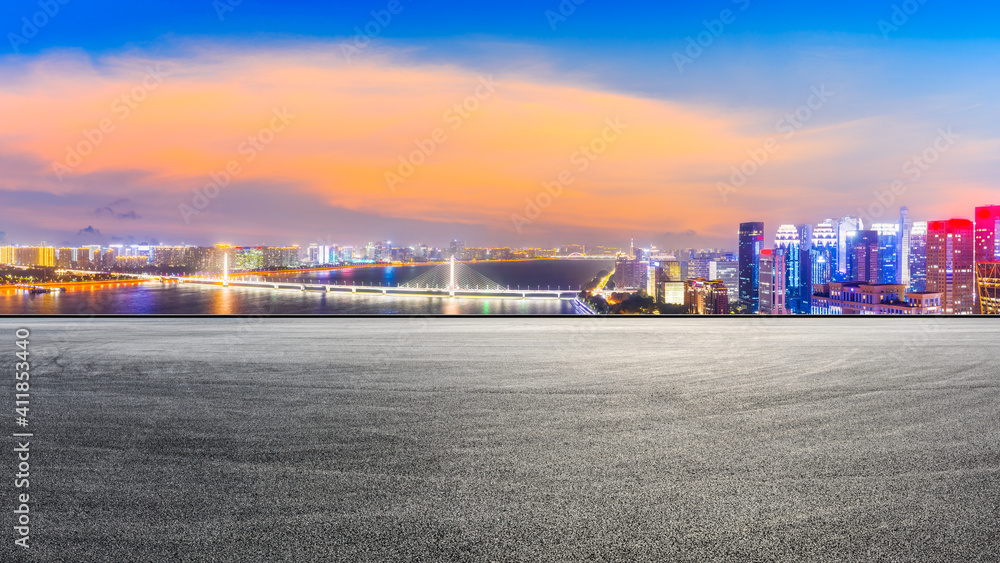 Race track road and modern city skyline with buildings in Hangzhou at night.