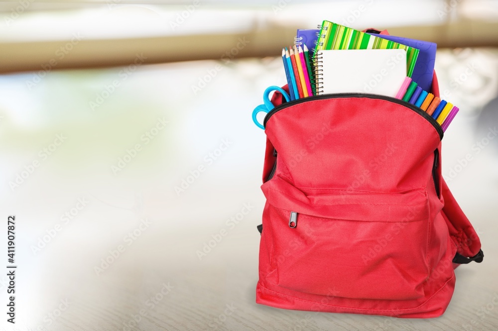 Modern schoolbag with various supplies for education