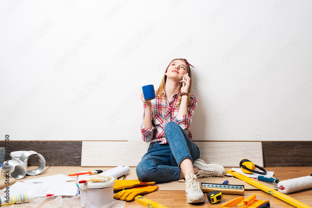 Dreamy girl talking on smartphone on floor