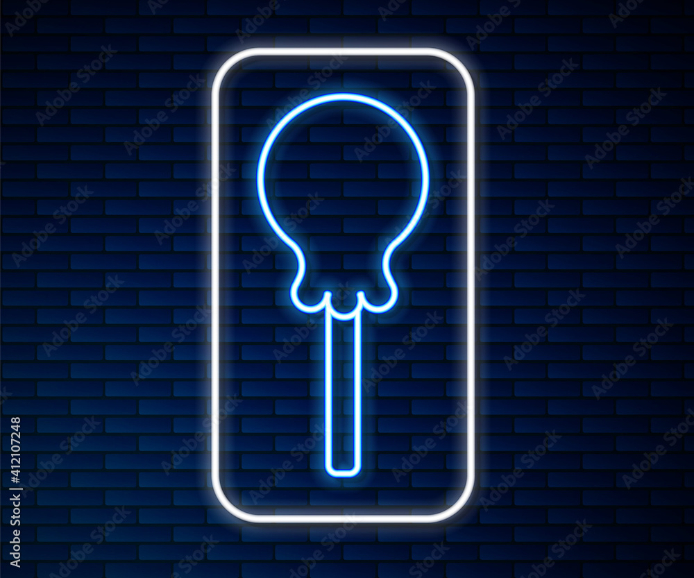 Glowing neon line Lollipop icon isolated on brick wall background. Food, delicious symbol. Vector.