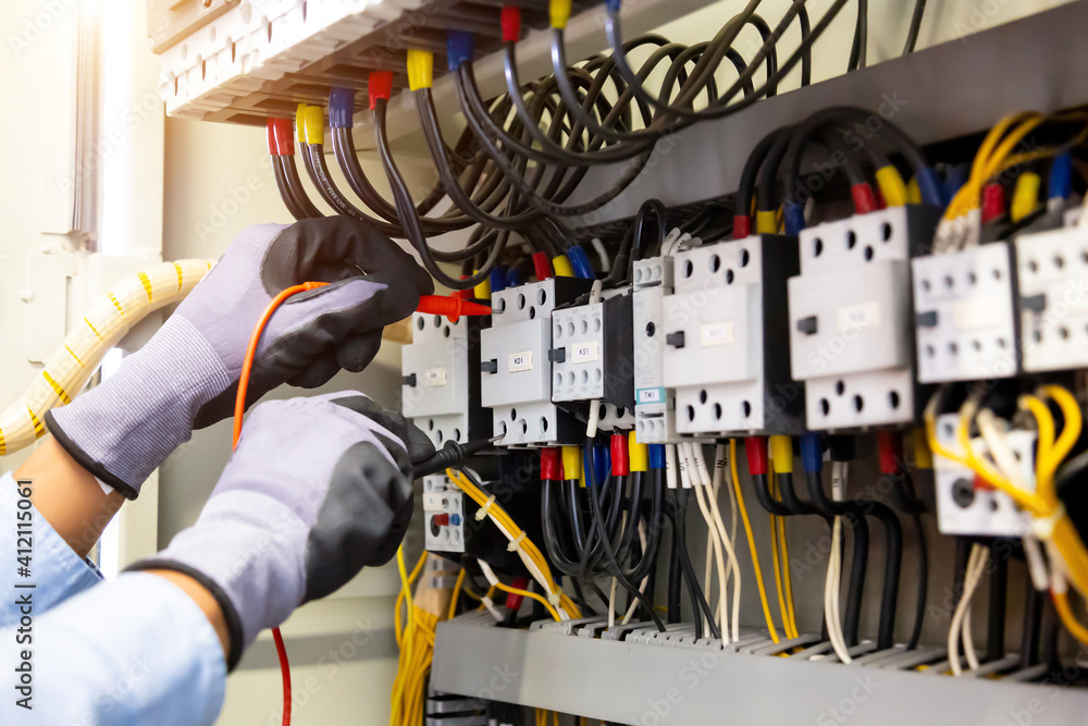 Electrical engineer using digital multi-meter measuring equipment to checking electric current volta