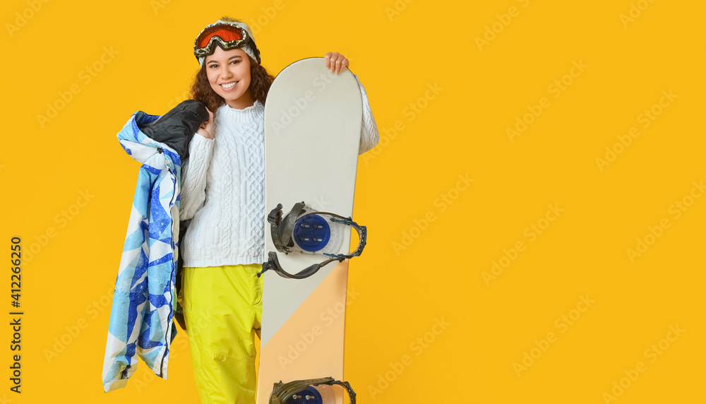 Female snowboarder on color background