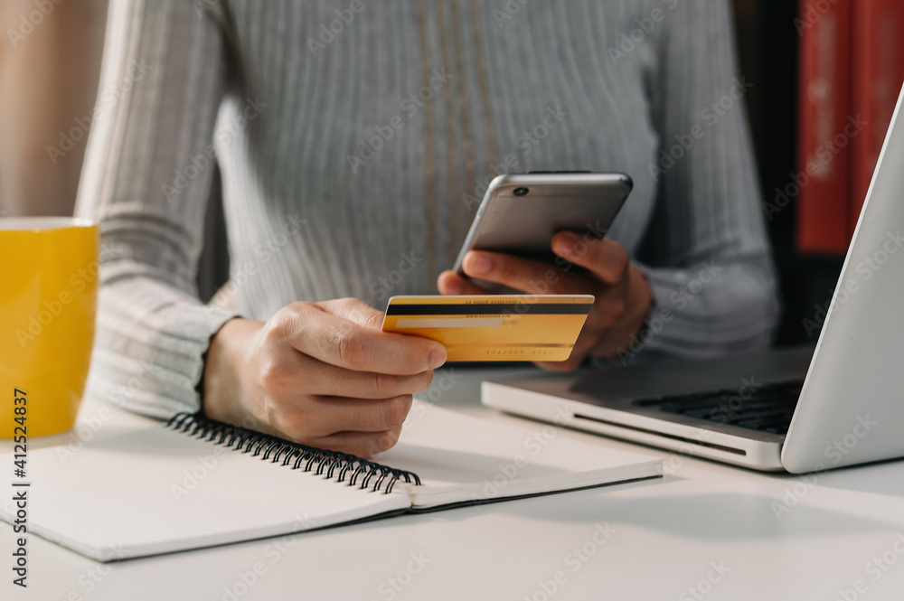  Woman using smart phone for mobile payments online shopping,omni channel,sitting on table,virtual i