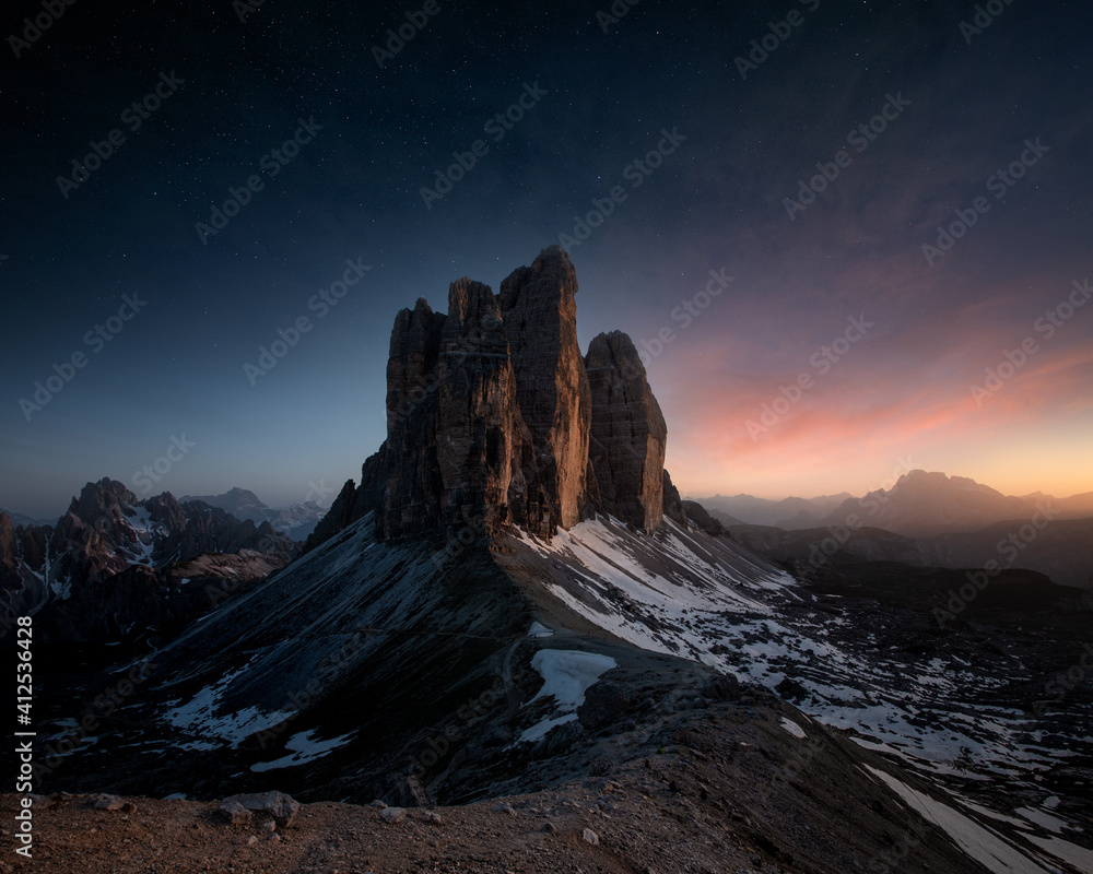 an epic view of Tre Cime Di Lavaredo mountain in sunset with stars on the sky