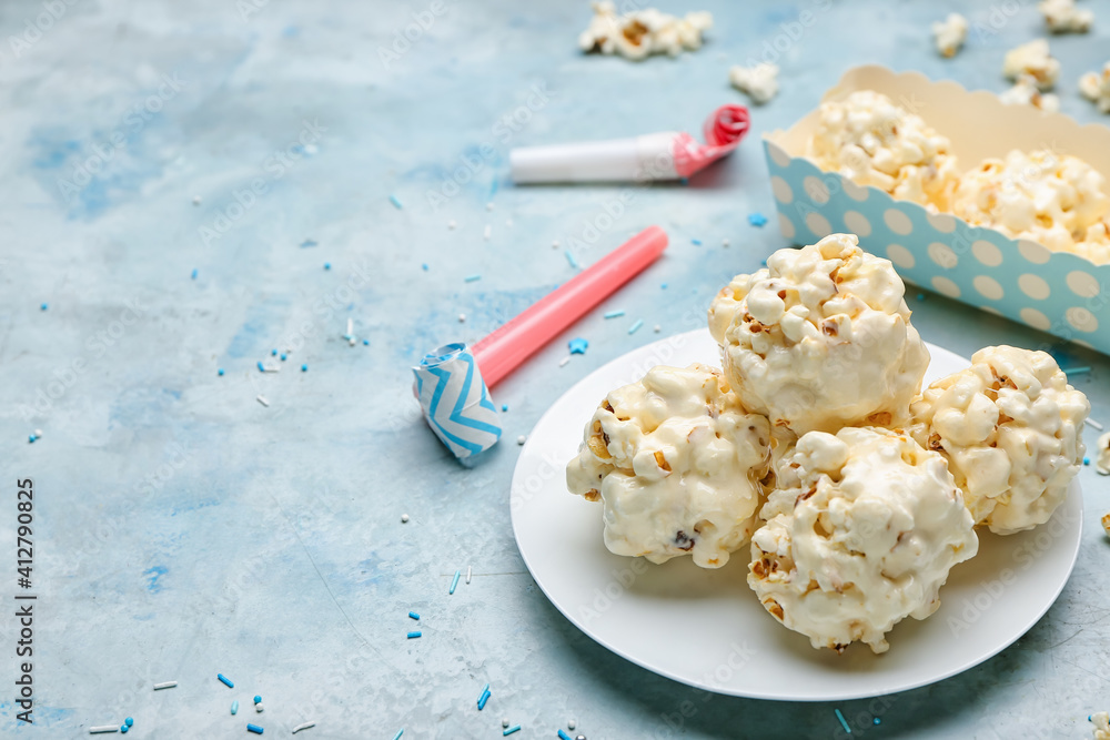 Plate with tasty popcorn balls on color background