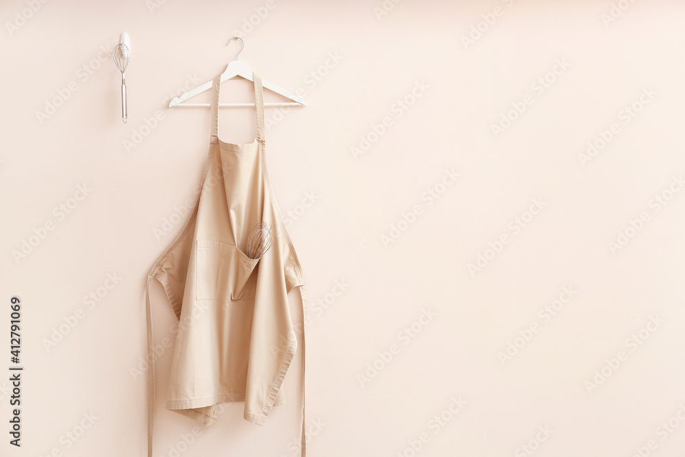 Clean apron and kitchen utensils on light background