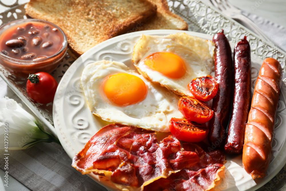 Traditional English breakfast with fried eggs in tray on light background