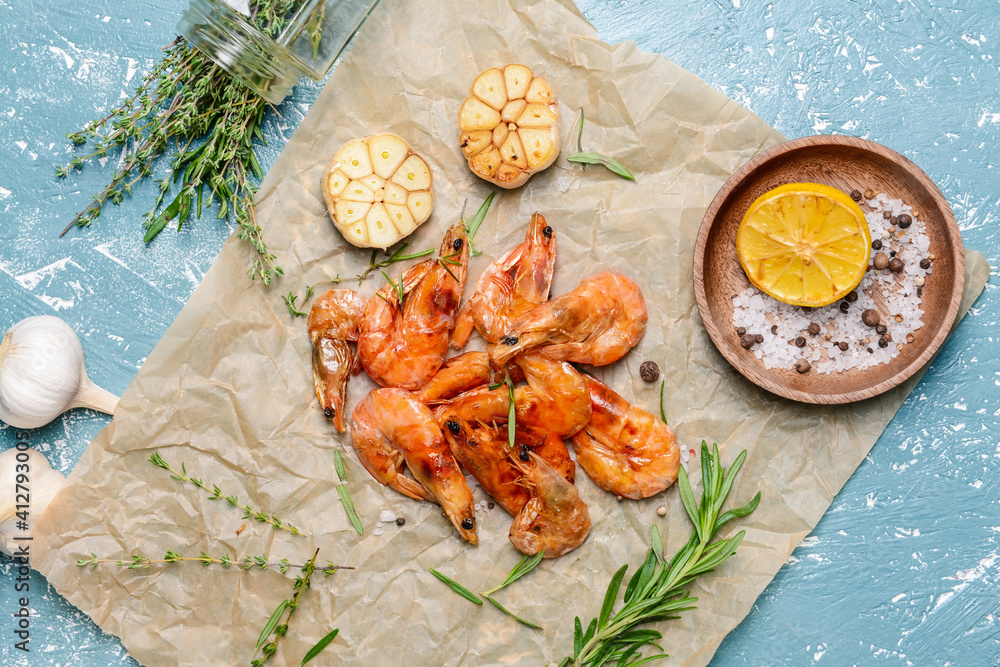 Parchment with tasty shrimps on color background