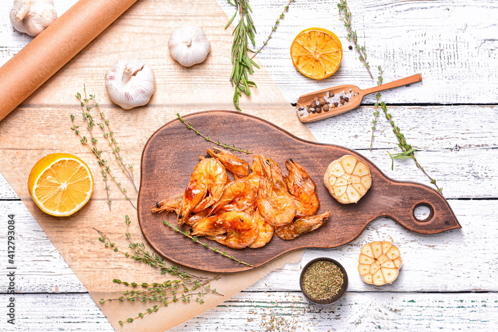 Board with tasty shrimps on wooden background