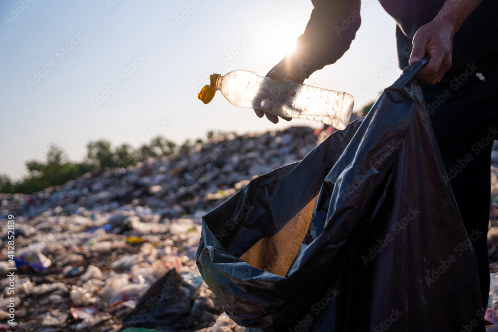 Close up hand collecting plastic bottle garbage for recycling concept reuse at the waste disposal si