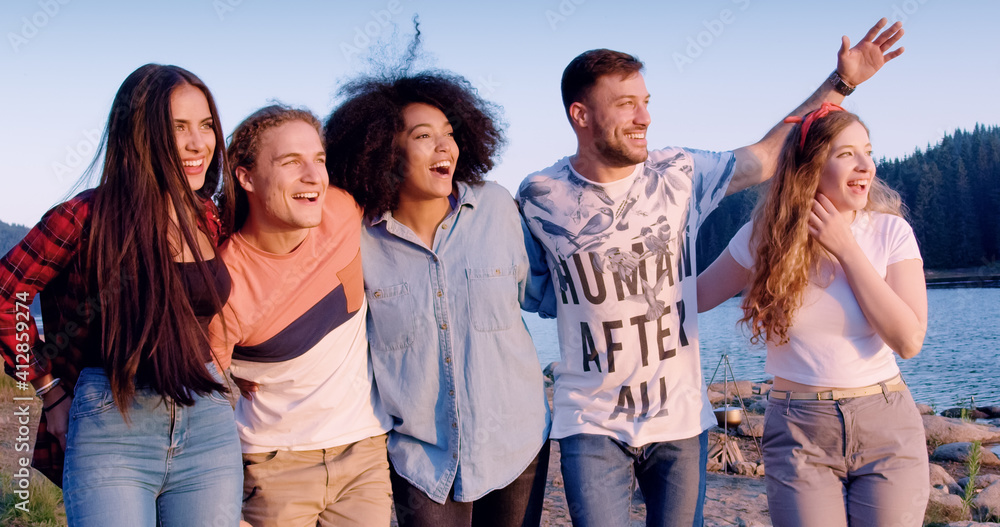 Group of happy friends explore nature lake shore compete nature tourism picnic party in nature conce