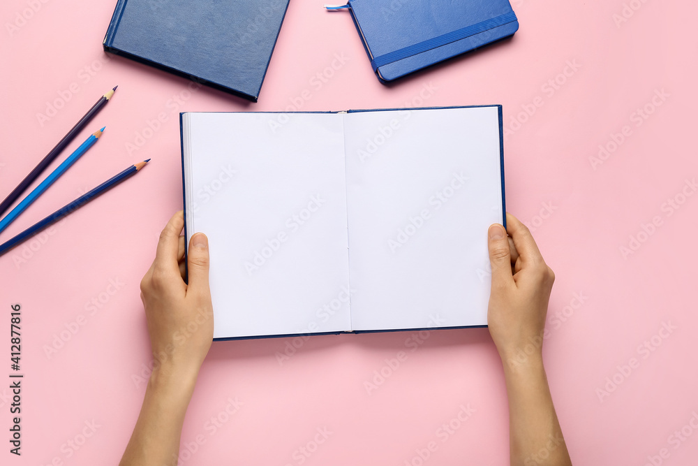 Female hands with blank book on color background