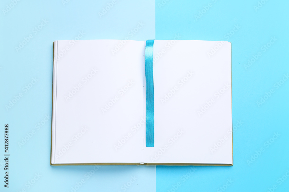 Blank book with bookmark on color background