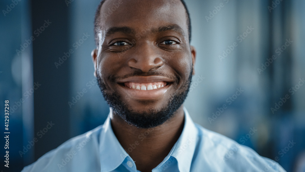 一位身穿浅蓝色休闲衬衫的黑人非裔美国英俊男子的特写肖像。成功