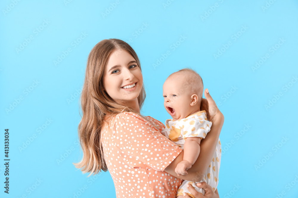 Happy mother with cute little baby on color background