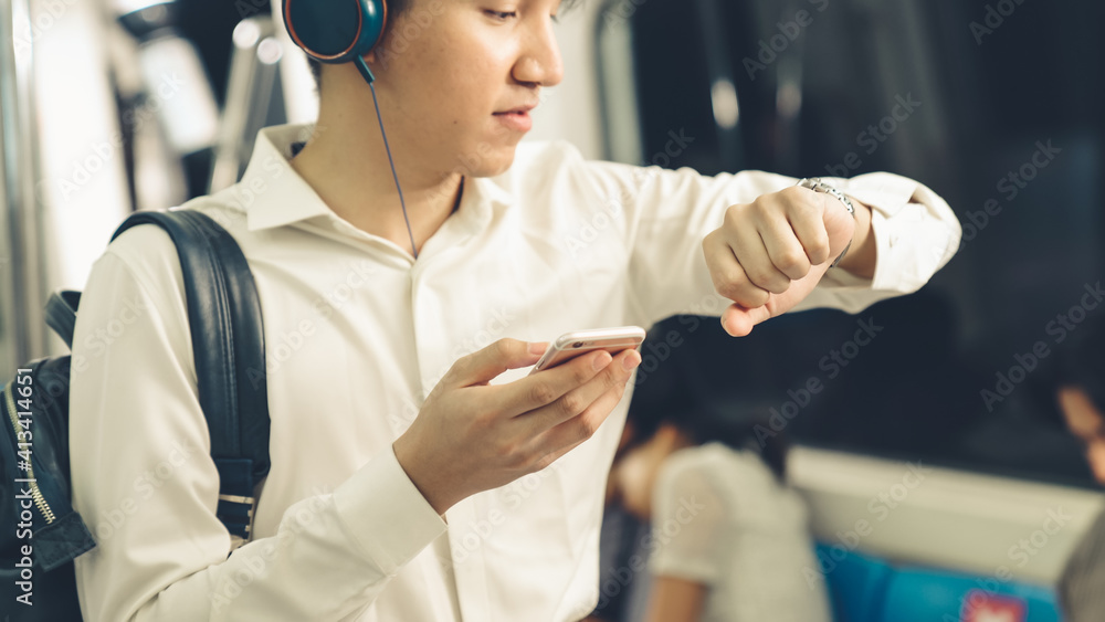 Businessman using mobile phone on public train . Urban city lifestyle commuting concept .