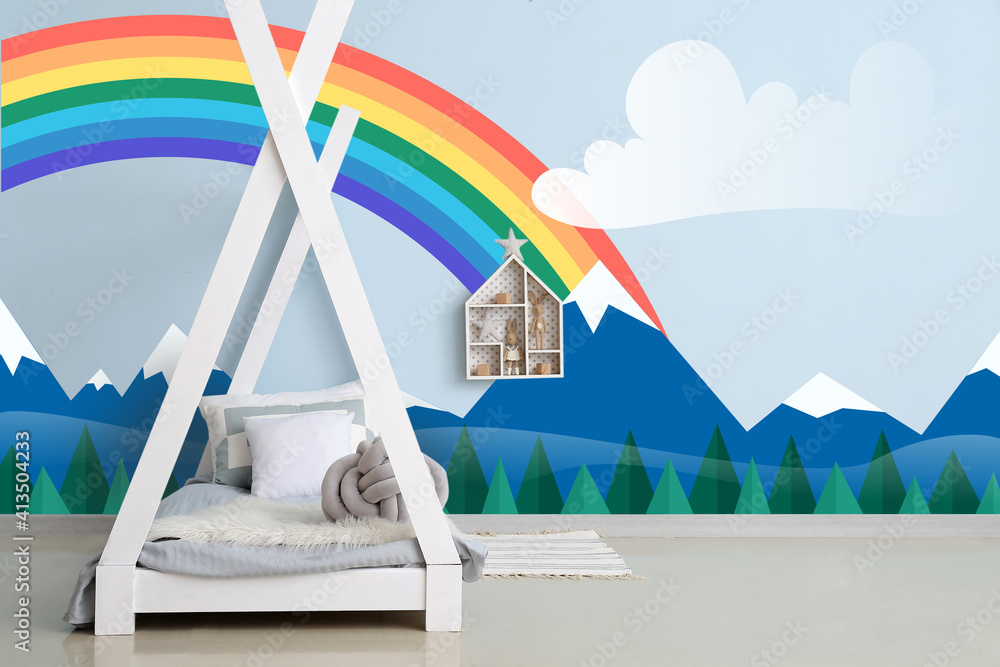 Interior of modern childrens room with bed and painting of rainbow on wall