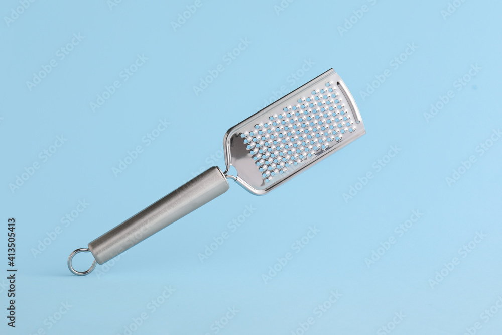 Metal grater on color background