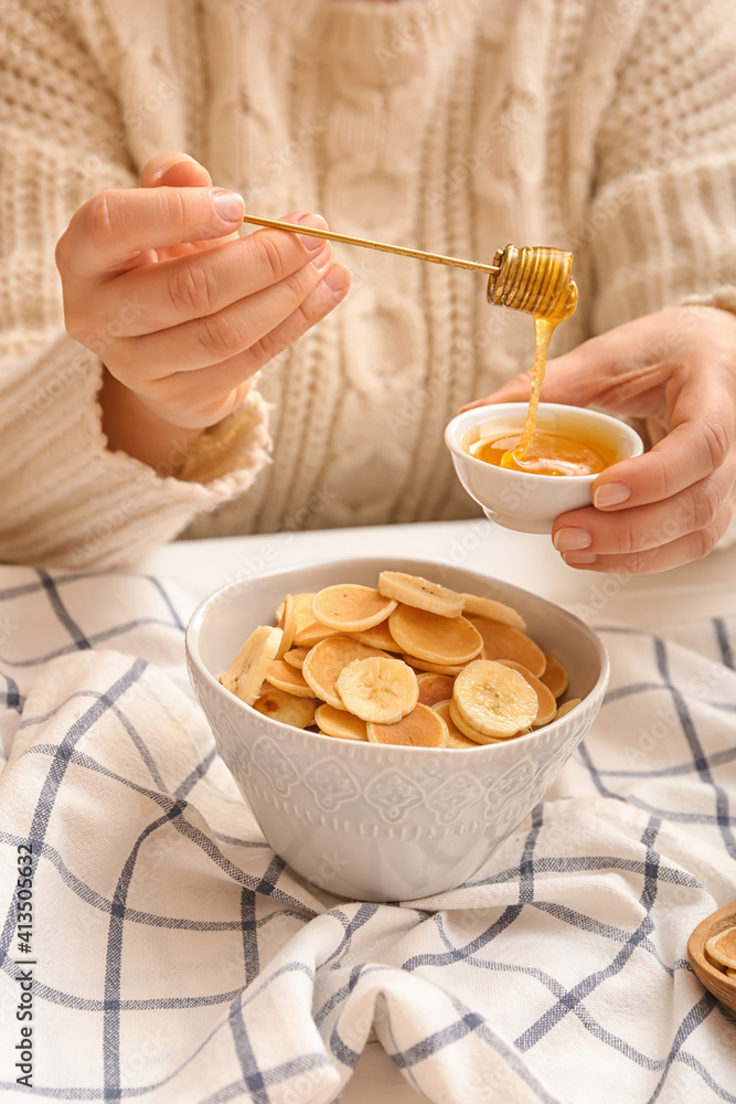 桌上有美味煎饼、香蕉和蜂蜜的女人，特写