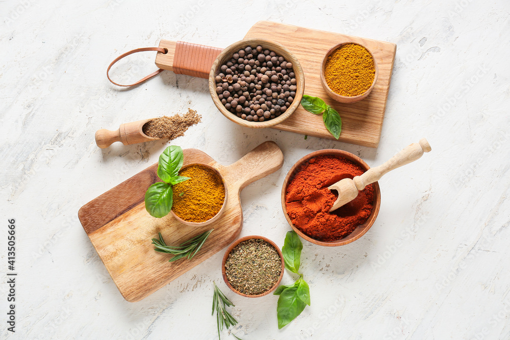 Bowls with different spices on light background