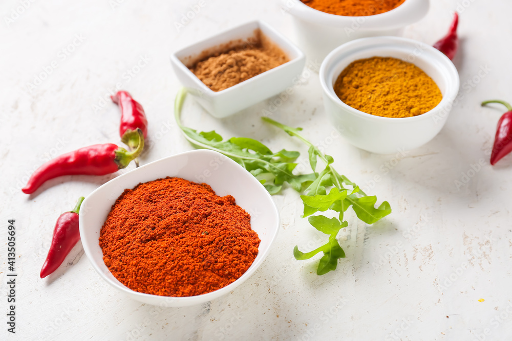 Bowls with different spices on light background