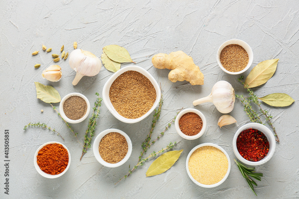 Bowls with different spices on light background