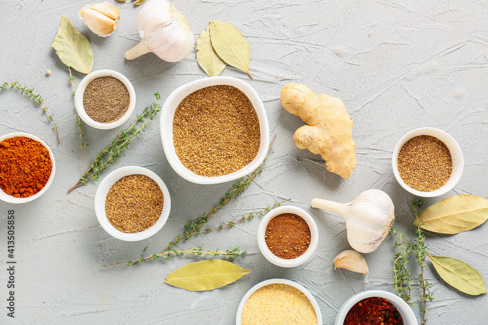 Bowls with different spices on light background