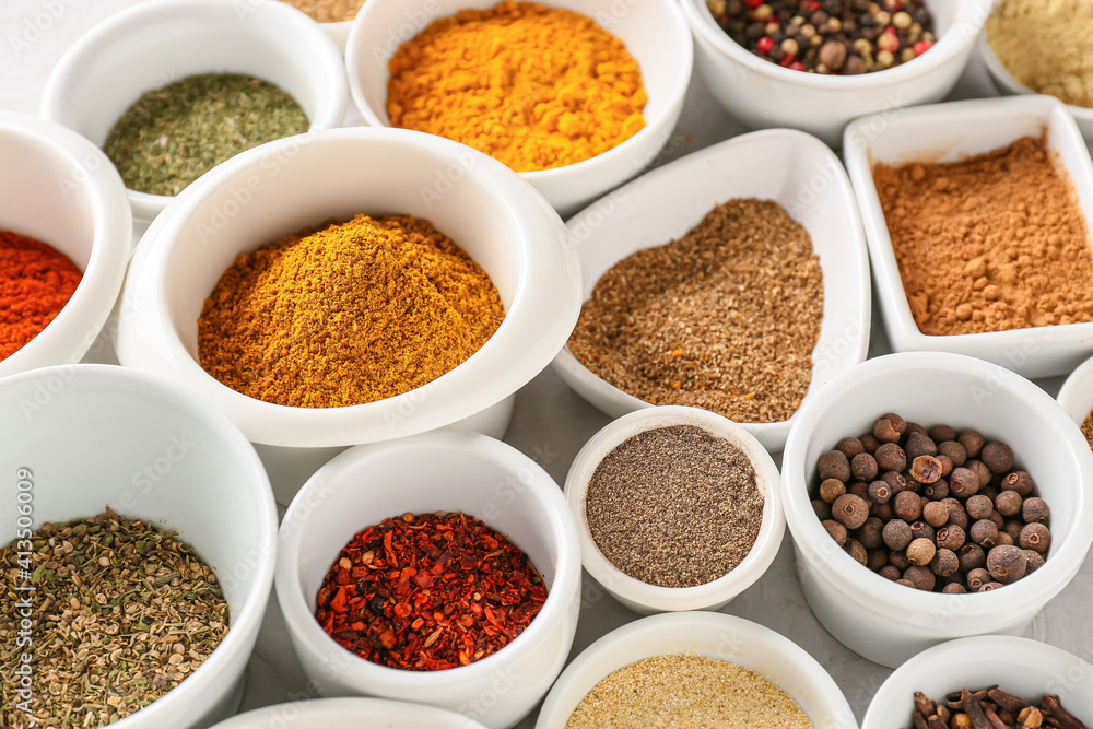 Bowls with different spices on light background, closeup