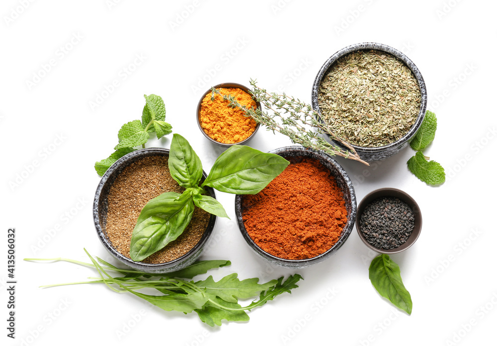 Bowls with different spices and herbs on white background