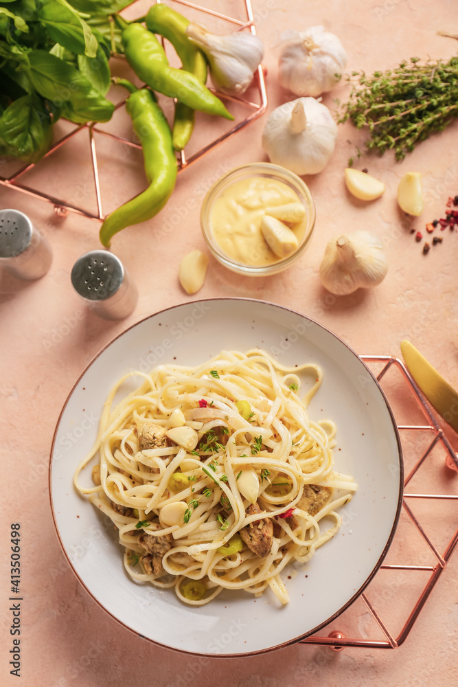 Plate with tasty noodles, chicken and ingredients on color background