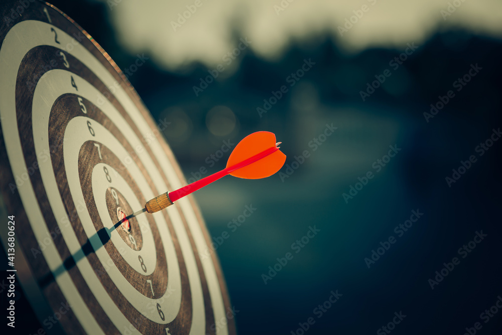 bullseye target or dart board has red dart arrow throw hitting the center of a shooting for business