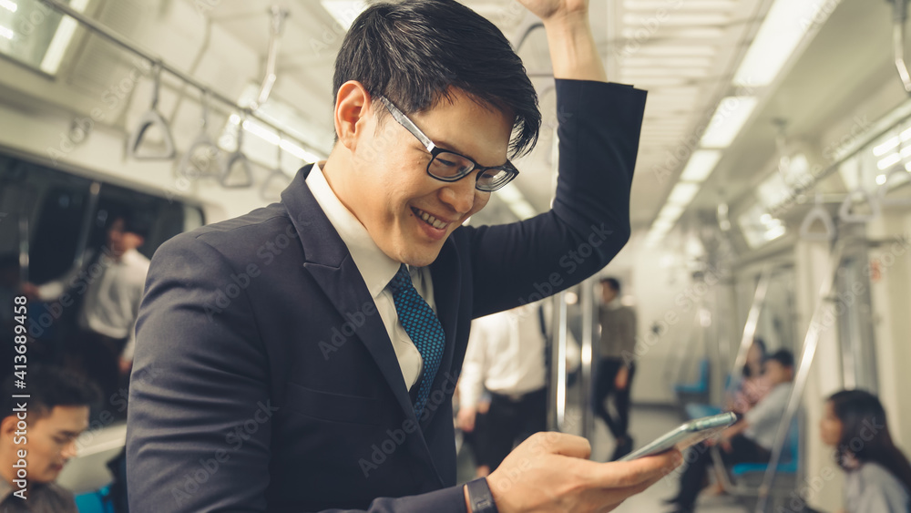 Businessman using mobile phone on public train . Urban city lifestyle commuting concept .