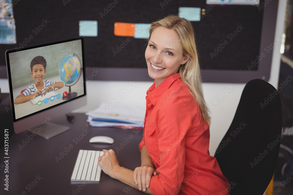 Portrait of female caucasian teacher having a video call with male student on computer at school