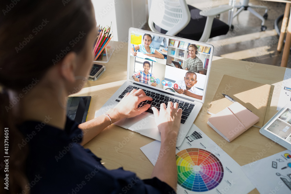 Female teacher having a video conference with multiple students on laptop at school