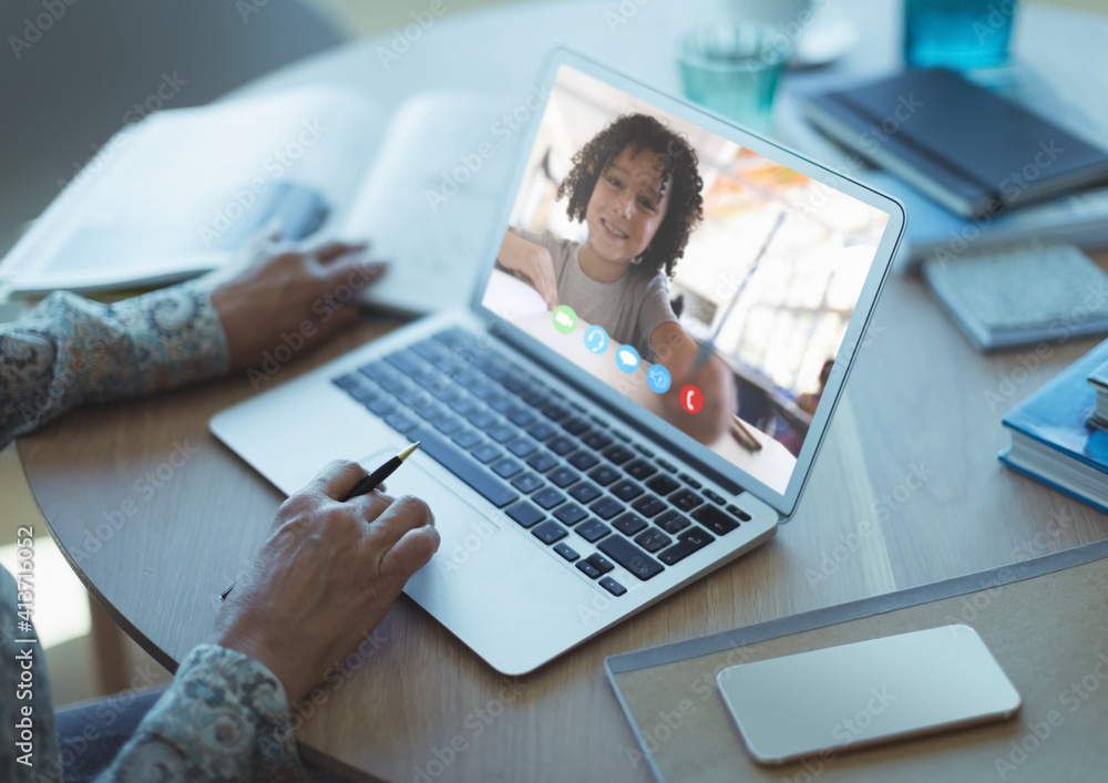 Mid section of female teacher having a video call with male student on laptop at school