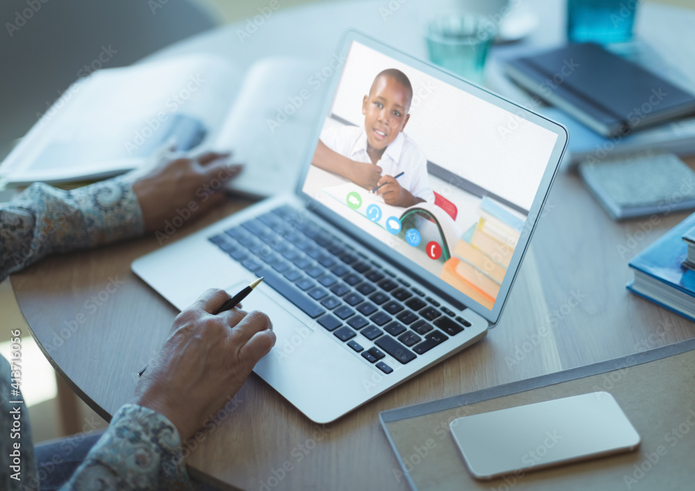 Mid section of female teacher having a video call with male student on laptop at school