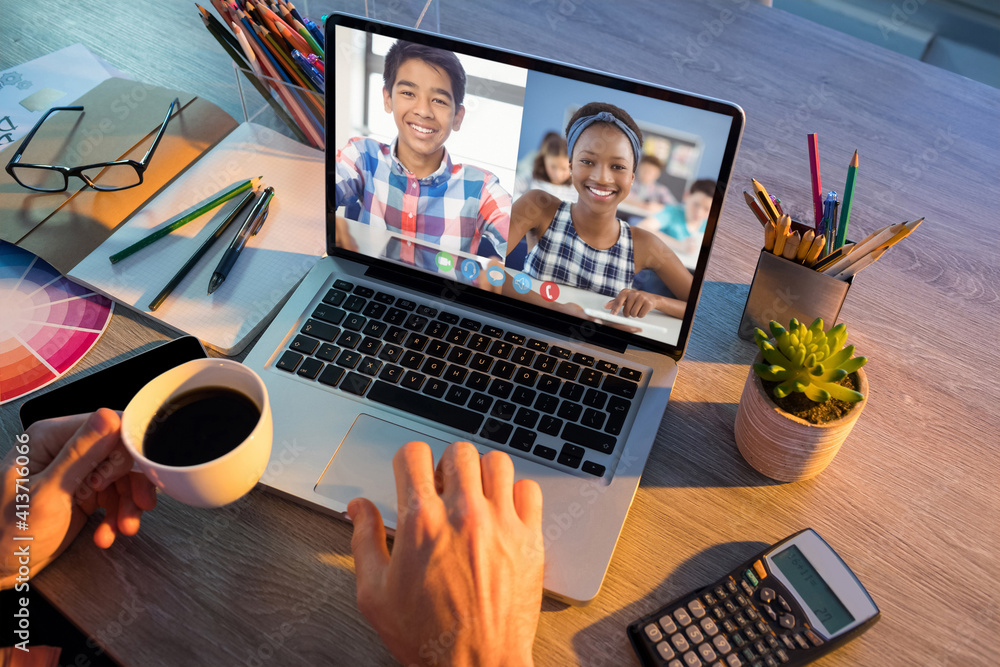 Mid section of teacher having a video conference with male and female students on laptop at school