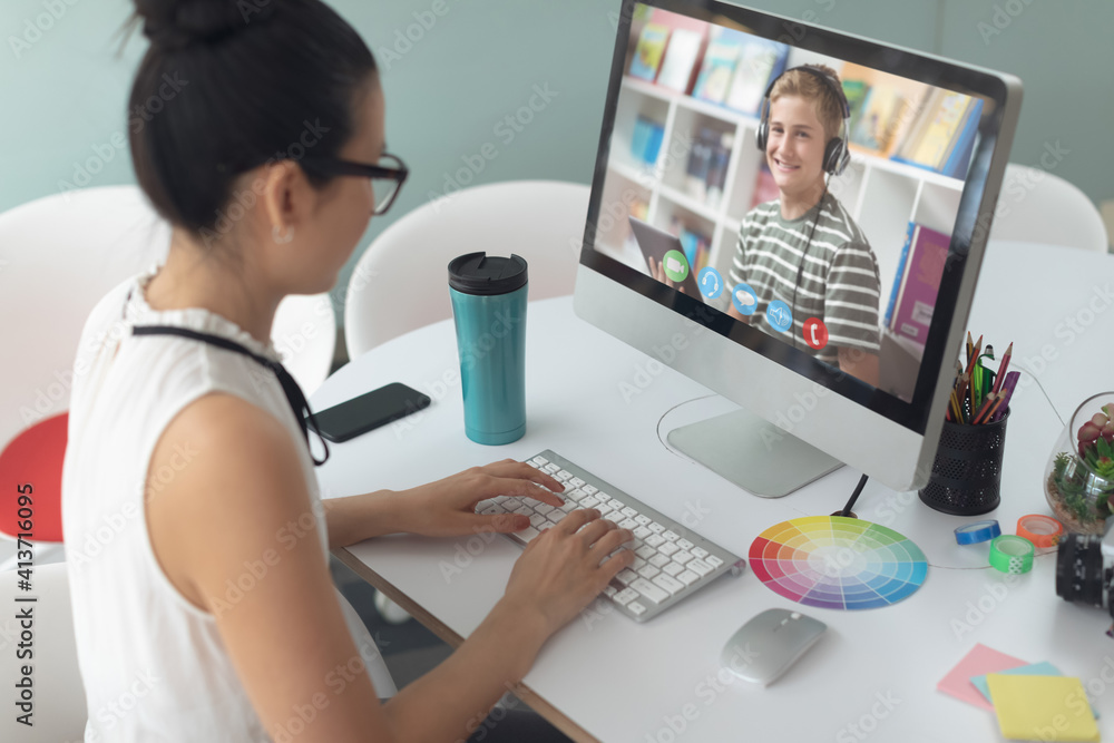 Female teacher having a video call with male student on computer at school