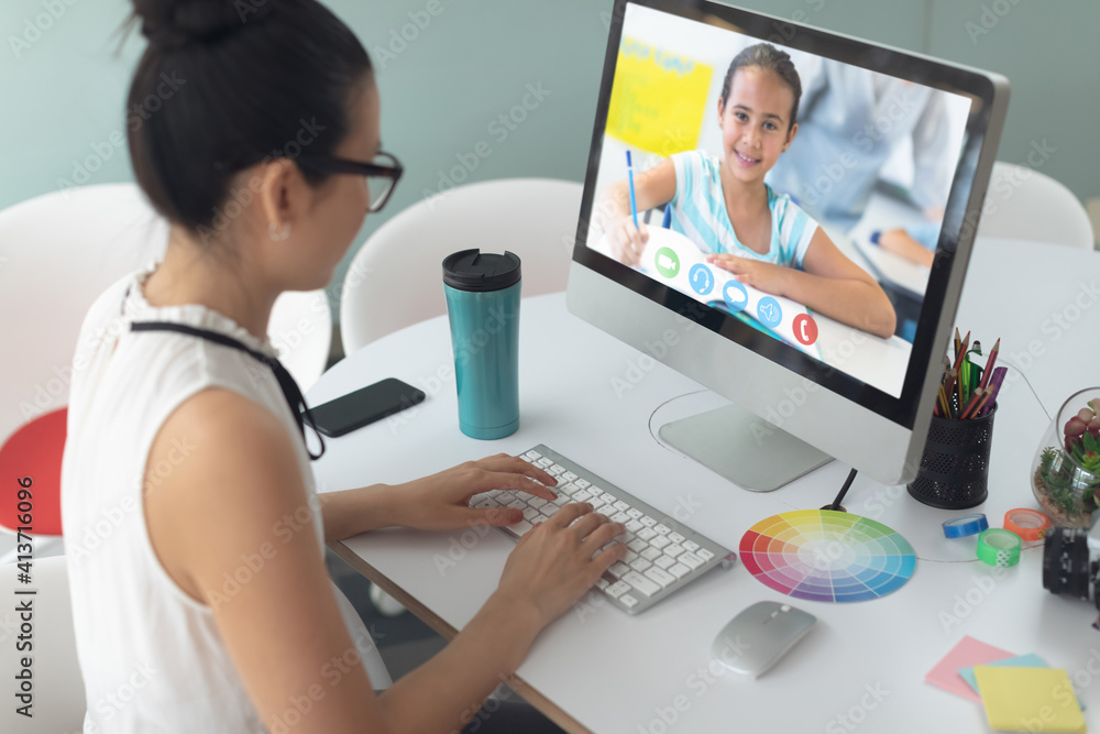 Female teacher having a video call with female student on computer at school