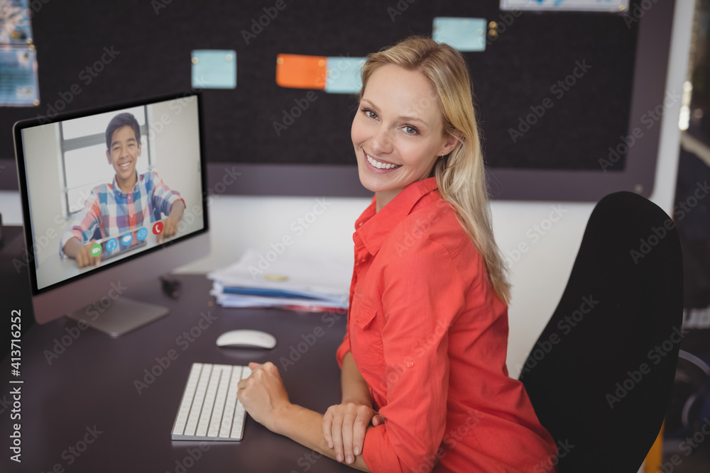 Portrait of female teacher having a video call with male student on computer at school