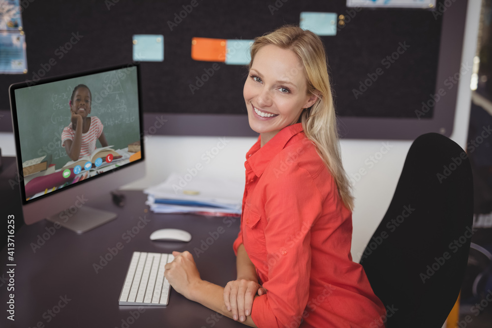 Portrait of female teacher having a video call with female student on computer at school