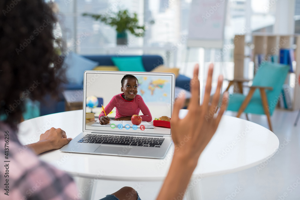 Female teacher having a video call with female student on laptop at school