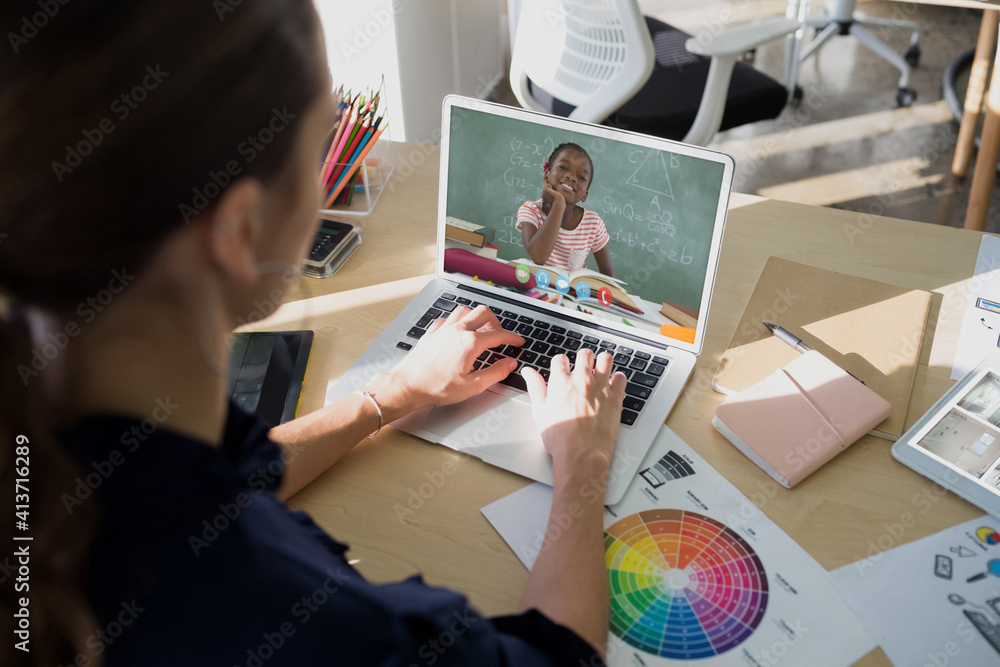 Female teacher having a video call with female student on laptop at school