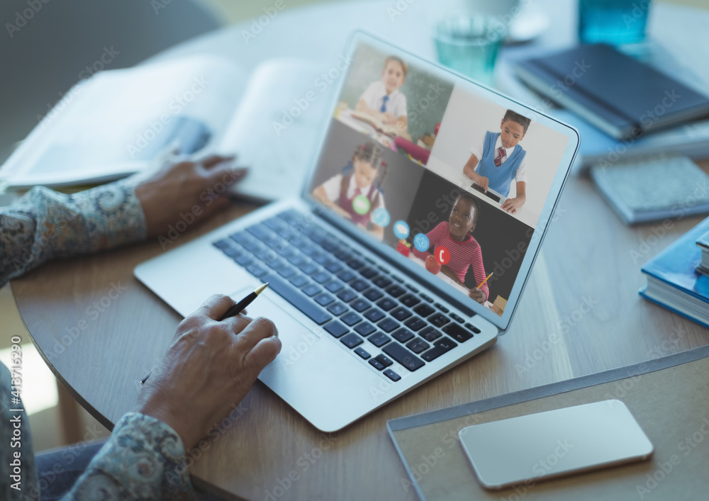 Mid section of female teacher having a video conference with multiple students on laptop at school