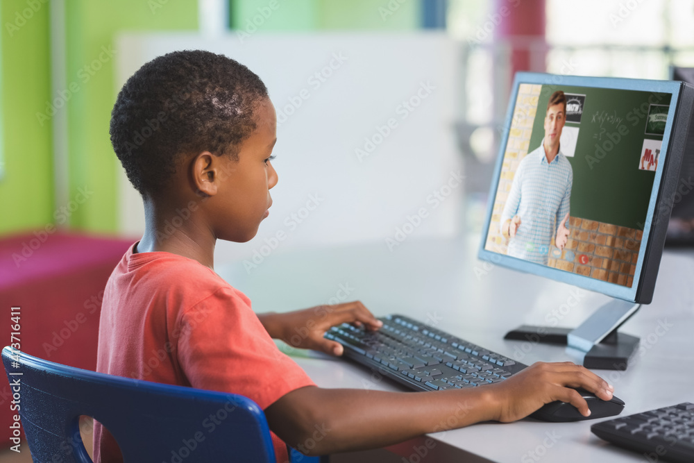 Male african american student having a video call with male teacher on computer at school