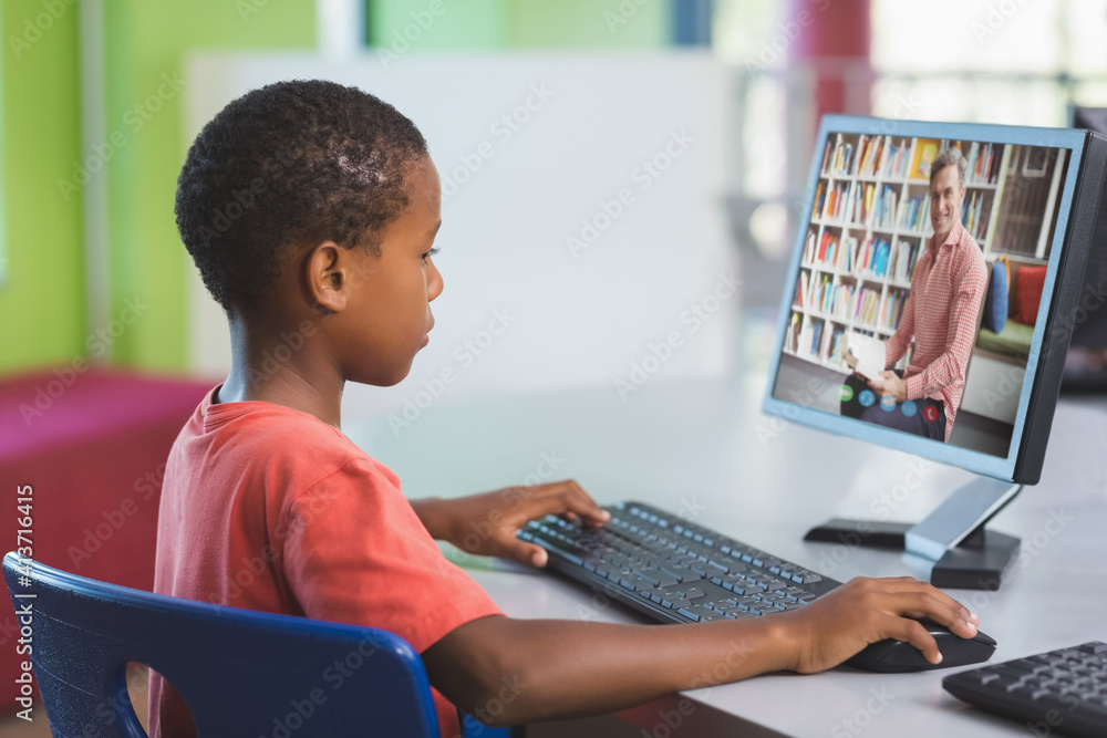 Male african american student having a video call with male teacher on computer at school