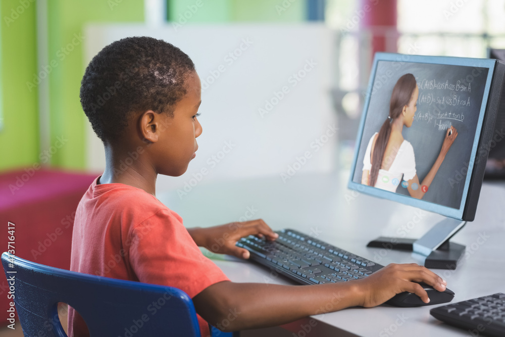 Male african american student having a video call with female teacher on computer at school