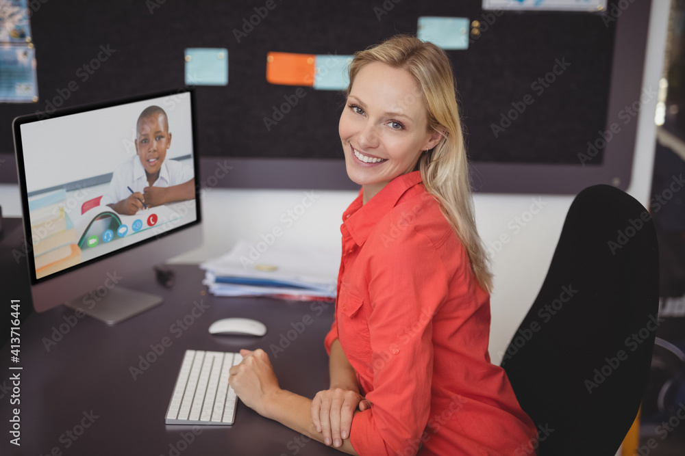 Portrait of female teacher having a video call with male student on computer at school