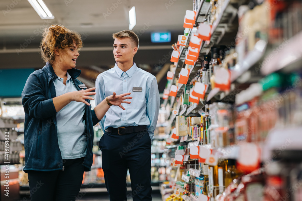 Supermarket manager giving training to a trainee