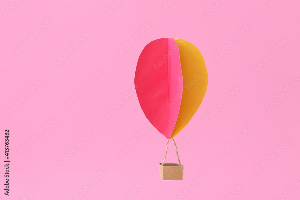 Paper hot air balloon on color background